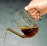 glass defatter with liquid being poured