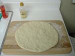 rolled out pizza dough on a cutting board